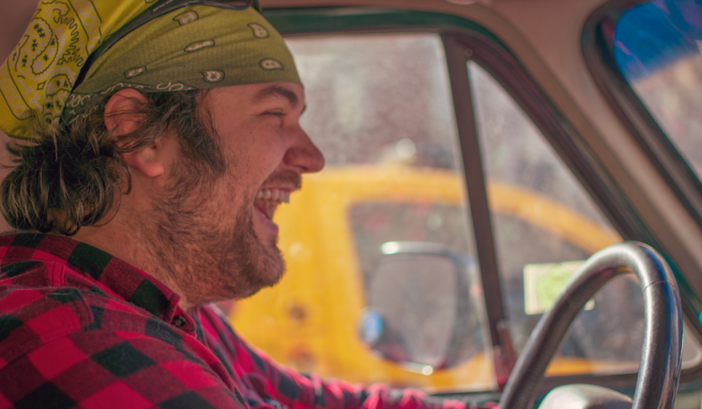Bearded man Laughs While Driving
