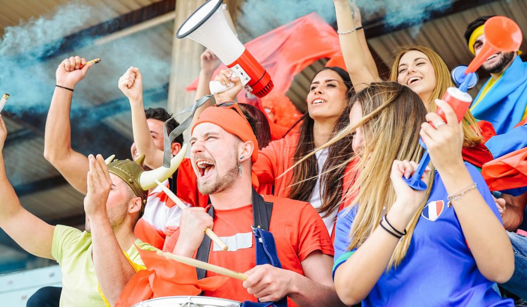 Football supporter fans watching match cheering at stadium