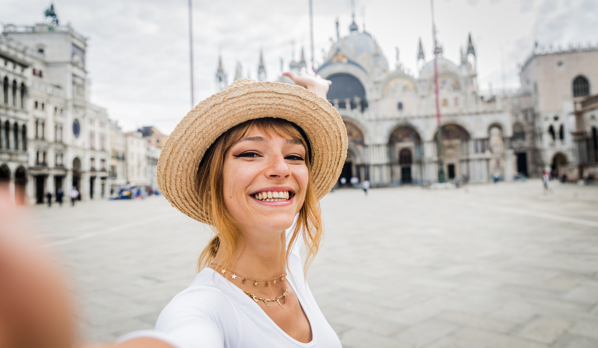 beautiful-young-woman-smiling-taking-selfie-travelling-alone-in-Italy