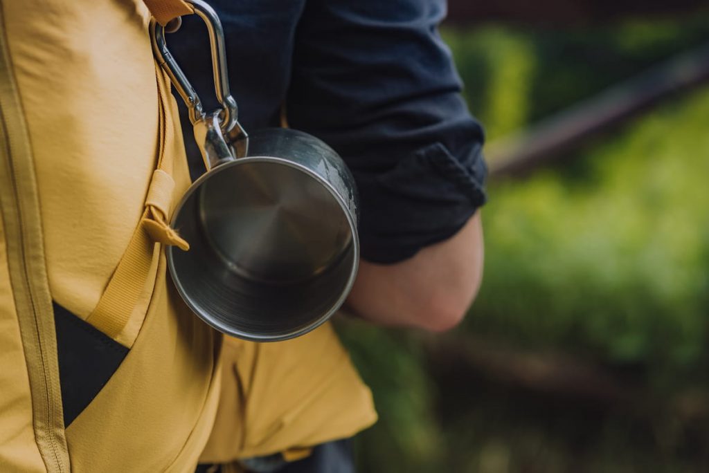 camping gear, metal cup and a backpack