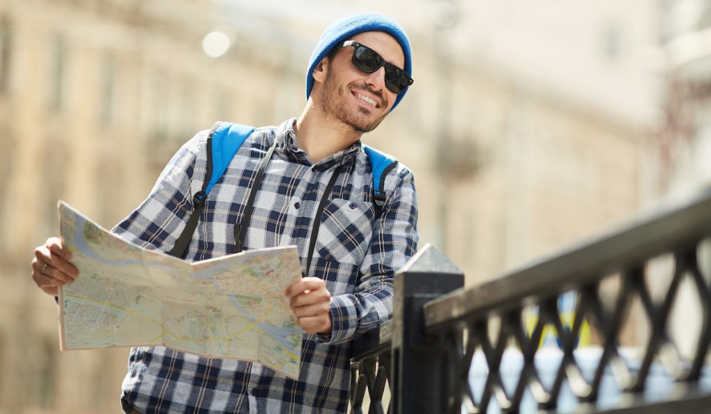 smiling man tourist holding map