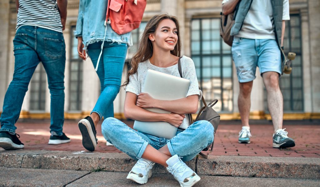 solo girl student sitting down on floor campus 