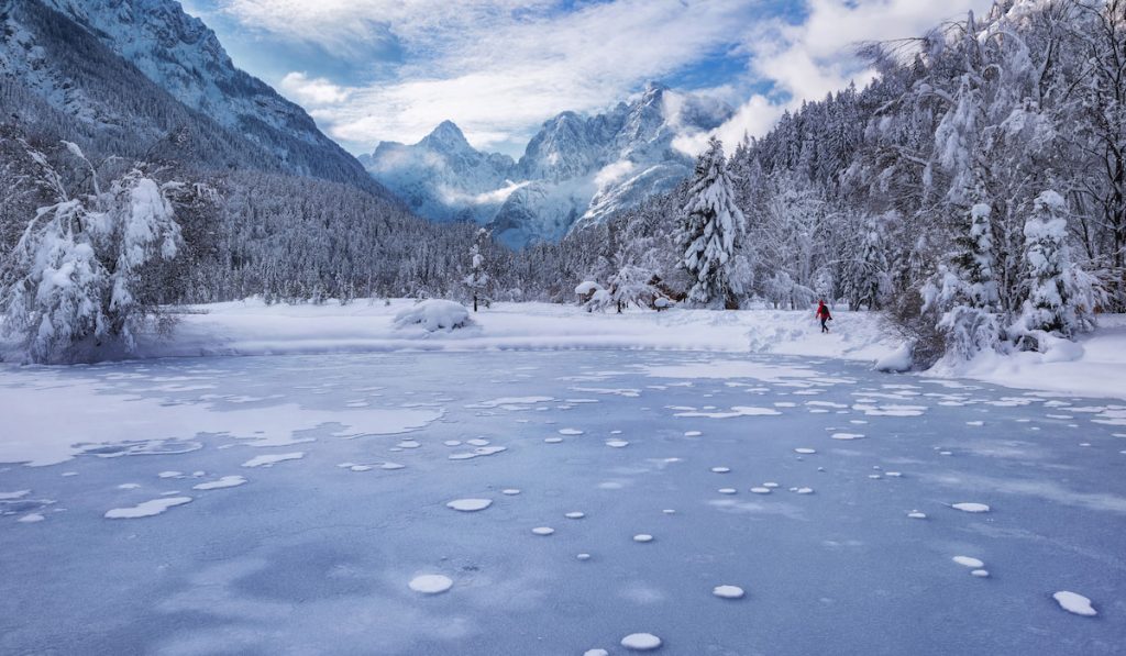 woman hiking besides the frozen lake 