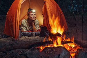 woman-lying-in-her-tent-with-headlight