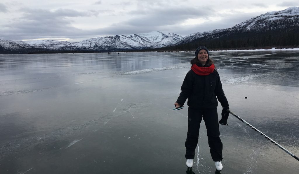woman standing frozen lake for skating 