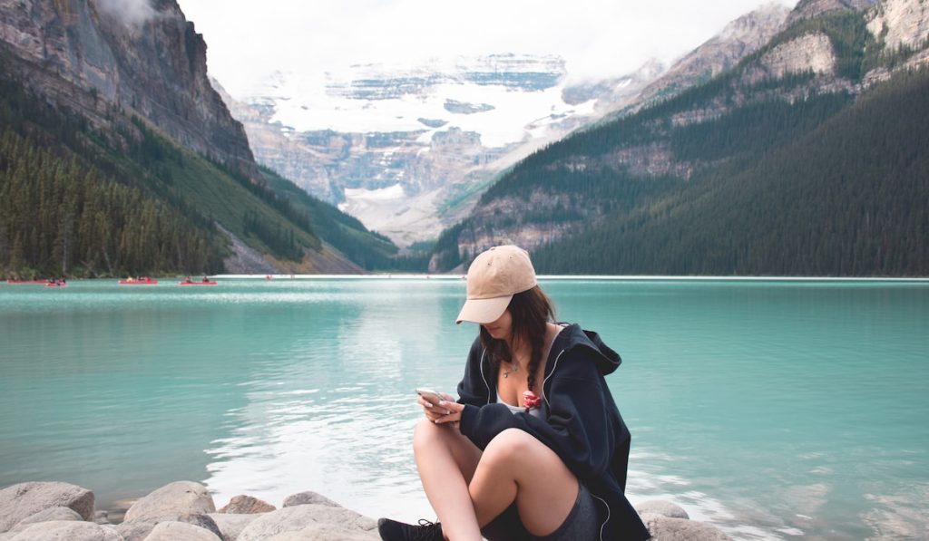 young girl sitting in front of lake louise