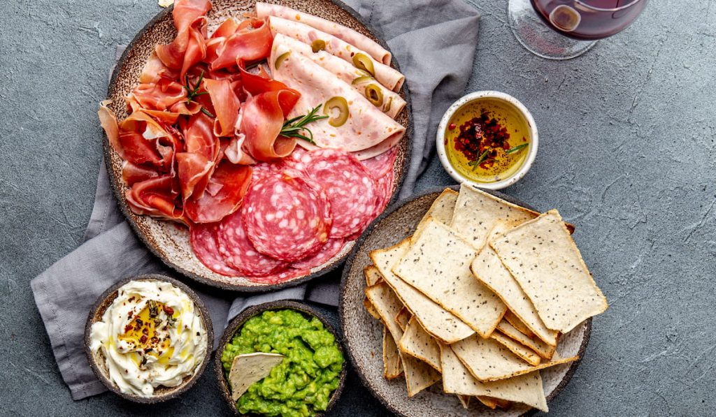 Antipasto. Meat platter, chips and sauces, red wine at a restaurant in Italy