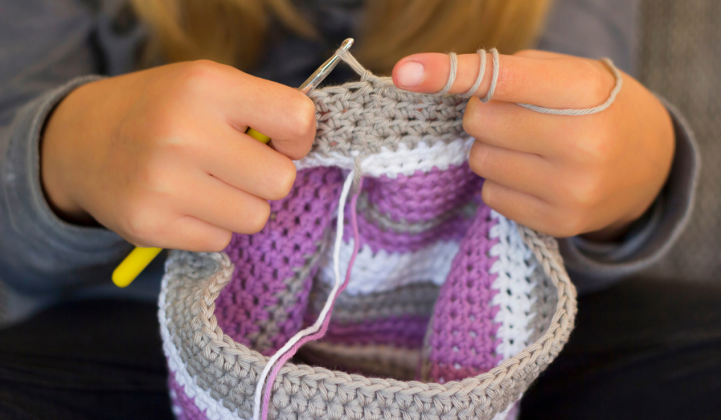 Girl crocheting a cap, close-up
